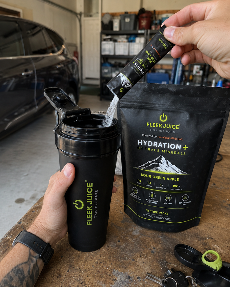 Pouring hydration supplement powder into shaker bottle with hydration mix pack on table