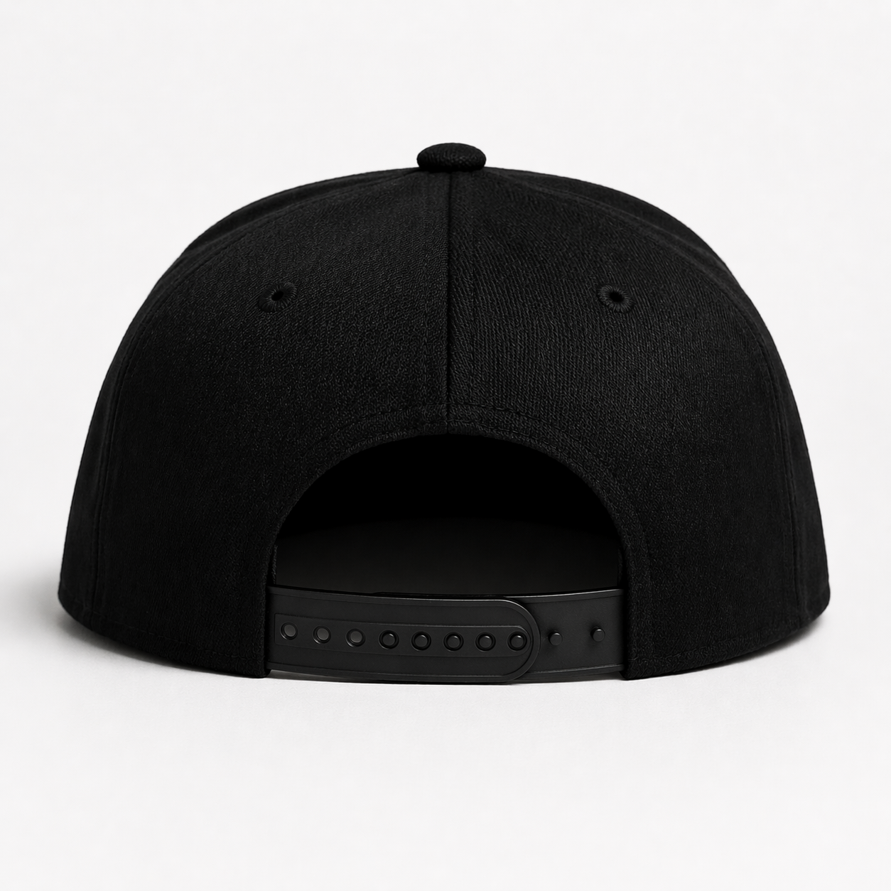 Back view of black snapback cap with adjustable strap on white background