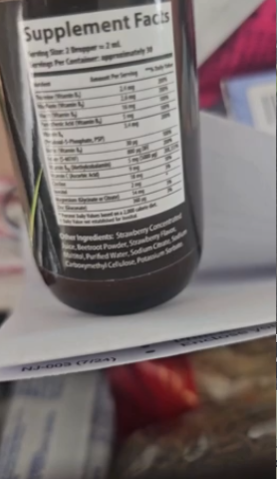 Bottle with supplement facts label, close-up, placed on a surface with blurred background